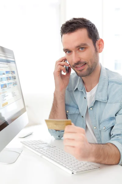 Young relaxed man paying online with his credit card — Stock Photo, Image