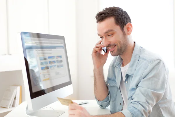 Young relaxed man paying online with his credit card — Stock Photo, Image