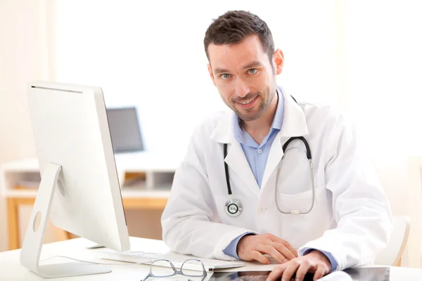 Portrait of a young smiling doctor in his office — Stock Photo, Image