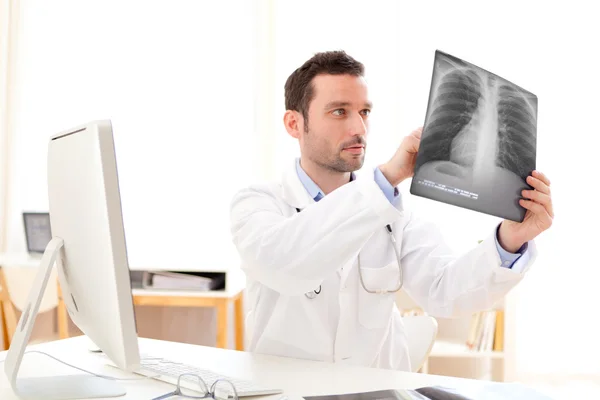 Junger Arzt bei der Analyse einer Röntgenaufnahme — Stockfoto