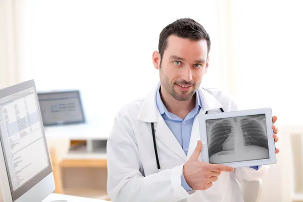 Médico joven mostrando radiografía en un comprimido — Foto de Stock