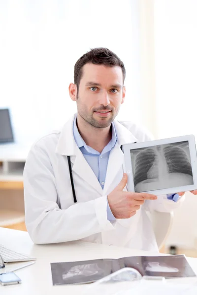 Jovem médico mostrando radiografia em um comprimido — Fotografia de Stock