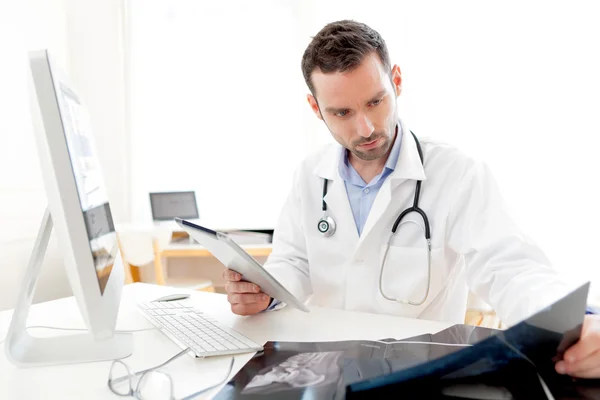 Retrato de um jovem médico usando comprimido no trabalho — Fotografia de Stock