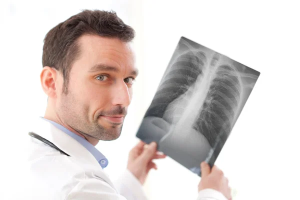 Retrato de un joven médico analizando una radiografía — Foto de Stock