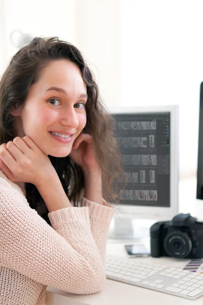 Jovem fotógrafa trabalhando em seu escritório — Fotografia de Stock