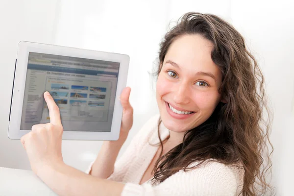 Portret van een jonge aantrekkelijke vrouw met behulp van Tablet PC op sofa — Stockfoto