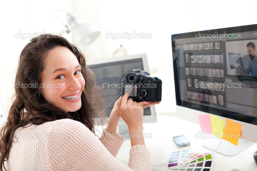 Young woman photographer watching pictures on camera 