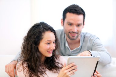 mutlu genç bir çift bir tablet üzerinde sörf