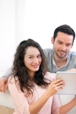 mutlu genç bir çift bir tablet üzerinde sörf