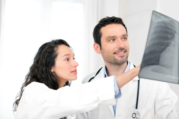 Jovem médico e enfermeiro analisando radiografia — Fotografia de Stock