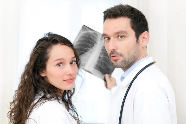 Médico joven y enfermera analizando radiografía — Foto de Stock