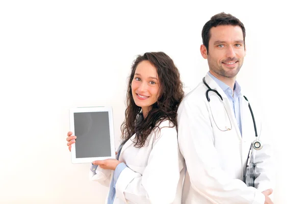 Retrato de um médico com sua enfermeira mostrando um tablet — Fotografia de Stock