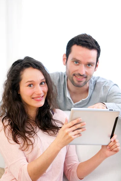 Feliz joven pareja surfeando en una tableta — Foto de Stock