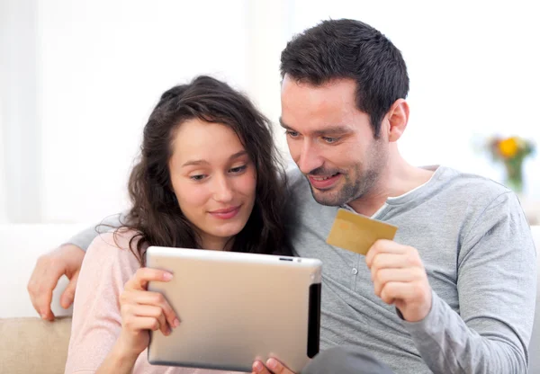 Jovem casal feliz compras em um tablet — Fotografia de Stock