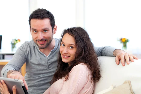 Feliz joven pareja surfeando en una tableta — Foto de Stock