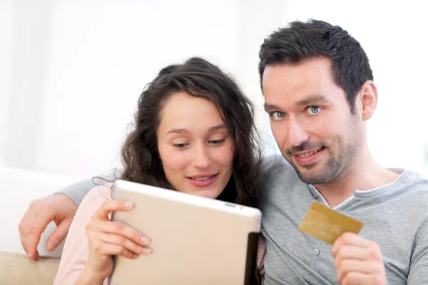 Jovem casal feliz compras em um tablet — Fotografia de Stock
