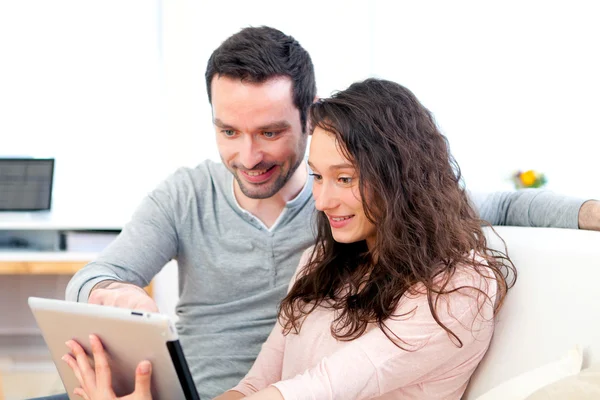 Feliz jovem casal surfar em um tablet — Fotografia de Stock