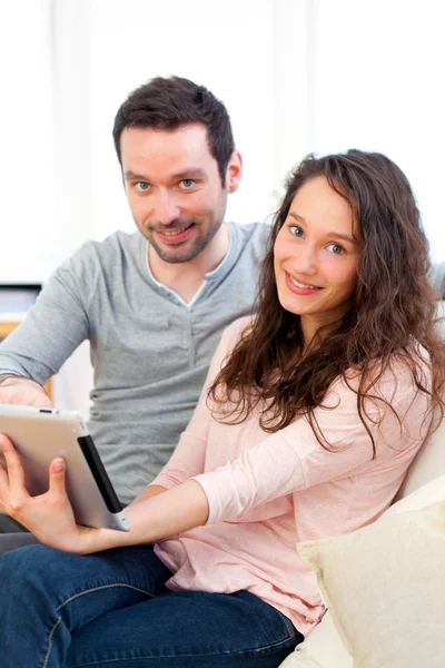 快乐的年轻夫妇，在平板电脑上冲浪 — 图库照片