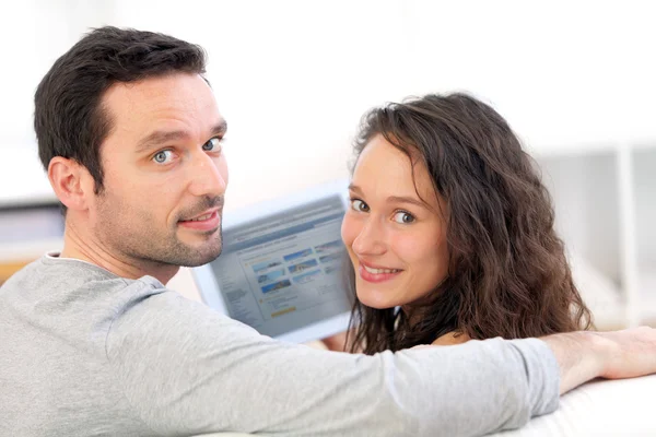 Feliz jovem casal surfar em um tablet — Fotografia de Stock