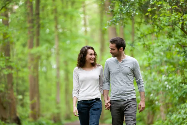 Young couple having a walk in a forest — Stock Photo, Image