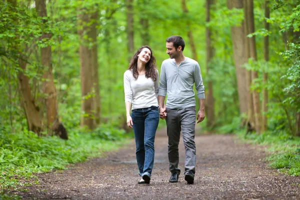 Jeune couple faisant une promenade dans une forêt — Photo