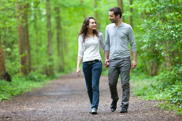 Jovem casal fazendo um passeio em uma floresta — Fotografia de Stock