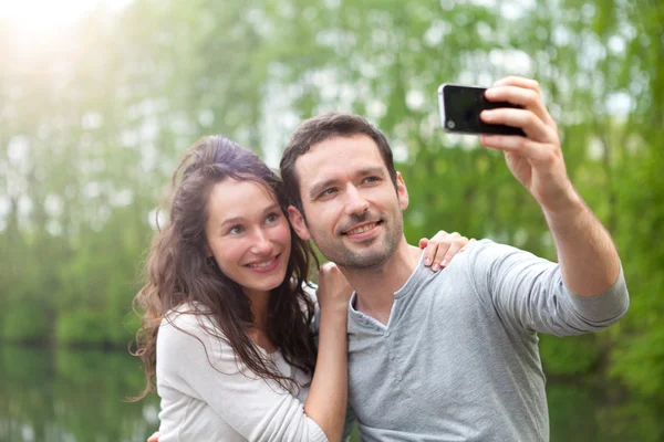 Młoda para przy selfie obraz w parku — Zdjęcie stockowe