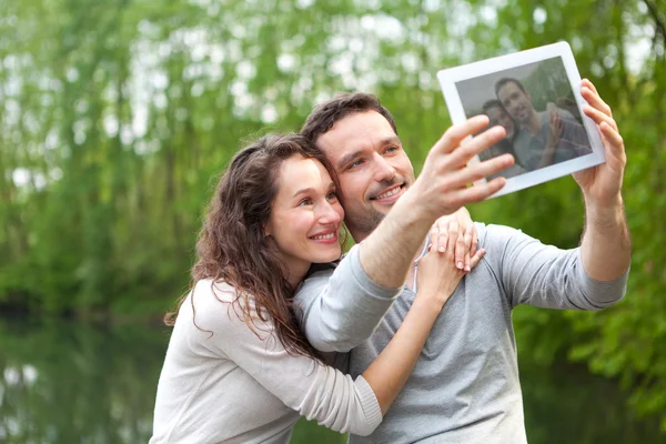 Mladý pár s selfie obrázek v parku — Stock fotografie