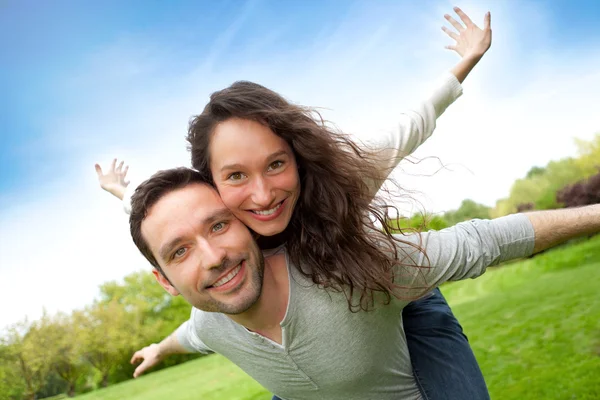 Joven pareja feliz divirtiéndose en el parque — Foto de Stock