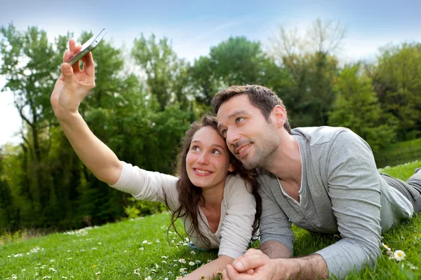 Mladý pár s selfie obrázek v parku — Stock fotografie