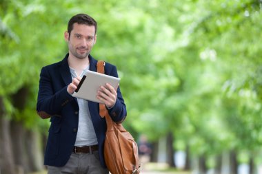 Paris'teki tablet kullanarak çekici genç bir adam