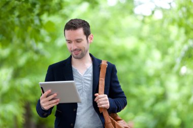 Paris'teki tablet kullanarak çekici genç bir adam