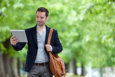 Paris'teki tablet kullanarak çekici genç bir adam