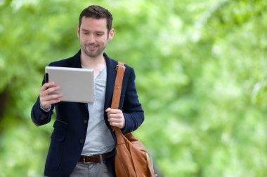 Paris'teki tablet kullanarak çekici genç bir adam