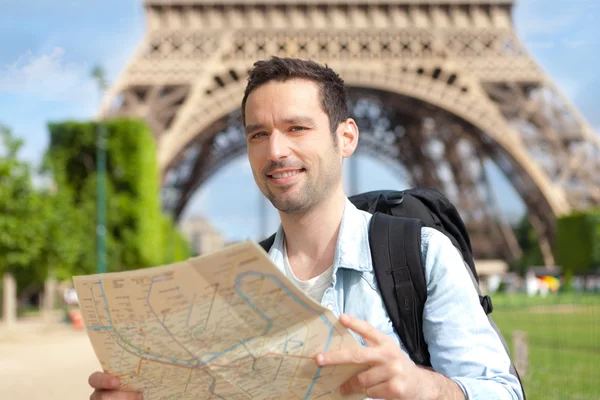 Young attractive tourist reading map in Paris — Stock Photo, Image