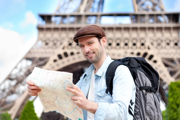 Young attractive tourist reading map in Paris — Stock Photo, Image