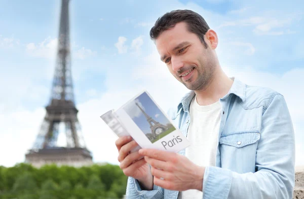 Ung attraktiv turist läsa en guide av paris — Stockfoto