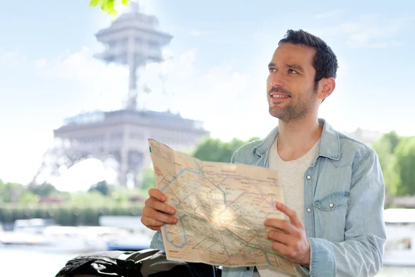 Young attractive tourist reading map in Paris