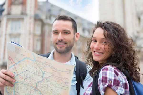 Couple of young attractive tourists watching map — Stock Photo, Image