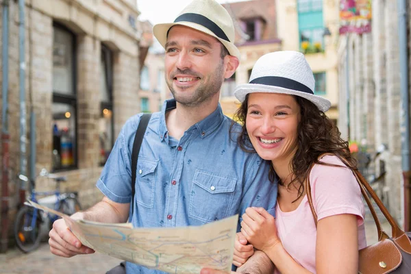 Couple of young attractive tourists watching map — Stock Photo, Image