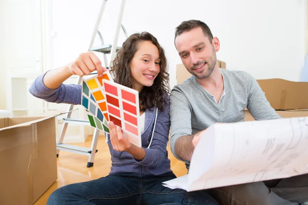 Молода пара вибирає кольори своєї нової квартири — стокове фото