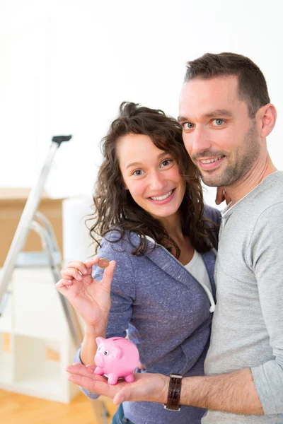 Young couple saving money in a piggy bank — Stock Photo, Image