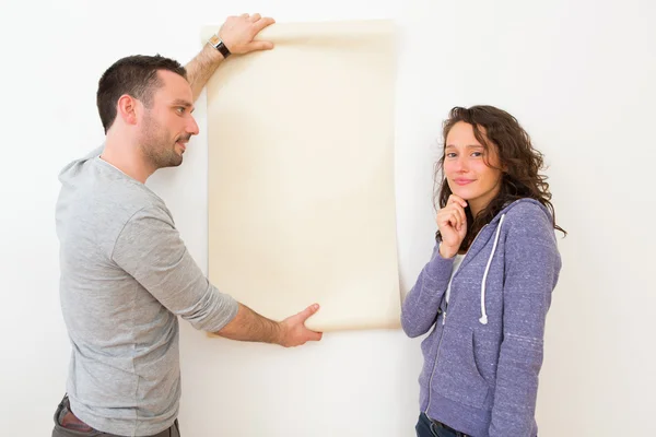 Young couple choosing their wallpaper — Stock Photo, Image