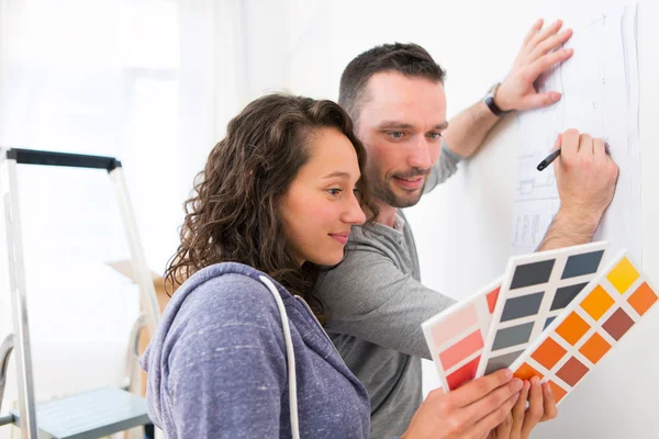 Young couple choosing colors of their new flat — Stock Photo, Image