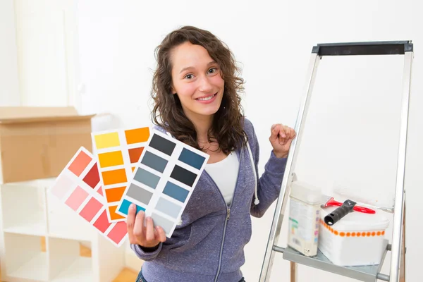 Mladá žena, výběr barvy z jejich nového bytu — Stock fotografie
