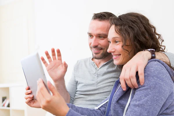 Jovem casal feliz chamada de vídeo no tablet — Fotografia de Stock