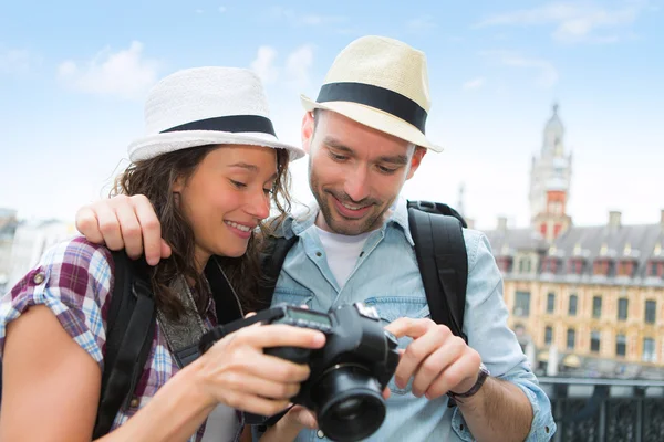 Pareja joven de turistas viendo fotografías — Foto de Stock