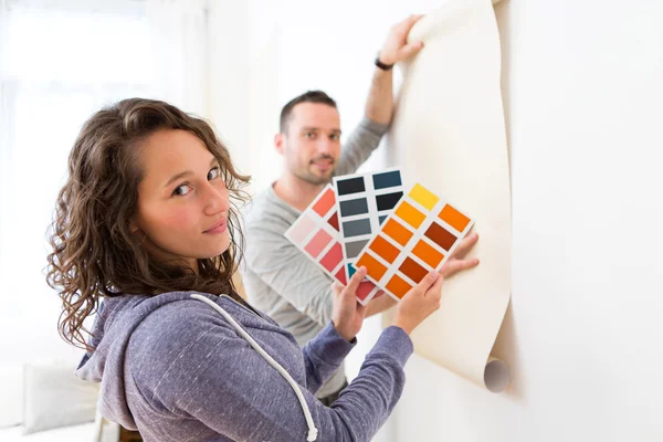 Young couple choosing colors of their wallpaper — Stock Photo, Image