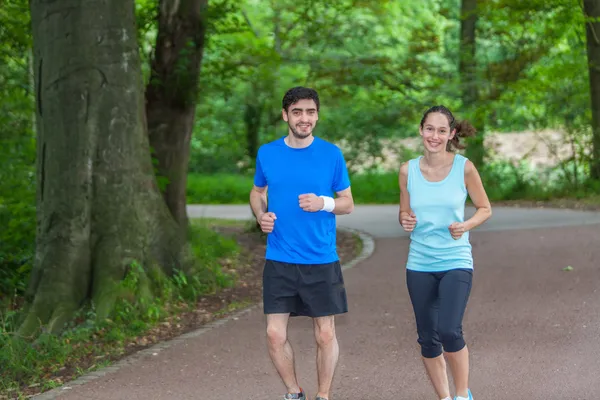 Sportliches junges Paar joggt im Park — Stockfoto