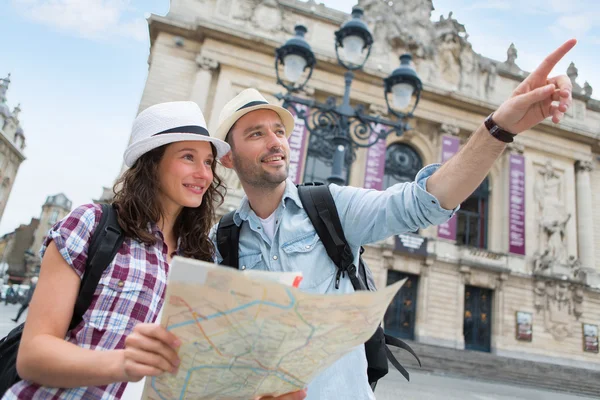 Pareja de turistas atractivos jóvenes viendo el mapa — Foto de Stock